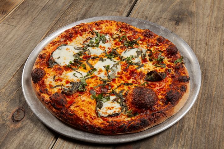 Golden crust pizza topped with basil and mozzarella