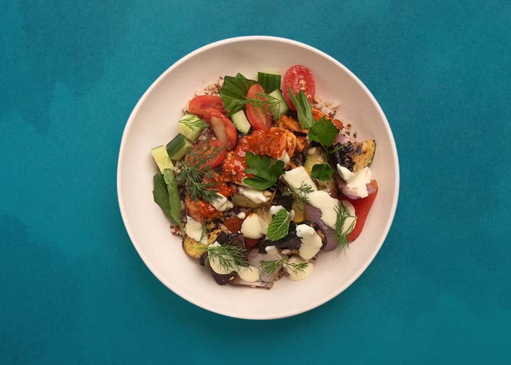 A robust and colorful salad, with tomatoes, quinoa rice, chicken and vegetables