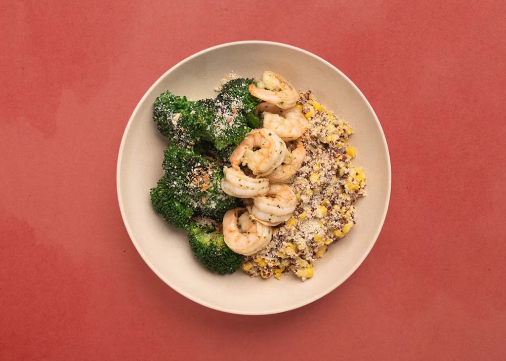 White plate filled one-third each by broccoli, shrimp, and sweet corn and quinoa pilaf